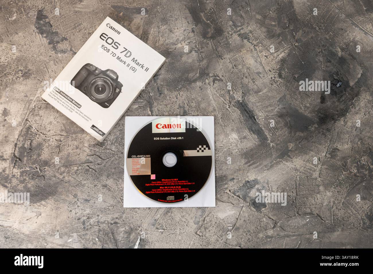 Guida dell'utente cartacea in inglese per la fotocamera DSLR Canon 7D Mark II con DVD EOS Solutions v29.1 in una custodia di carta piatta su una superficie ruvida grigia. Foto Stock