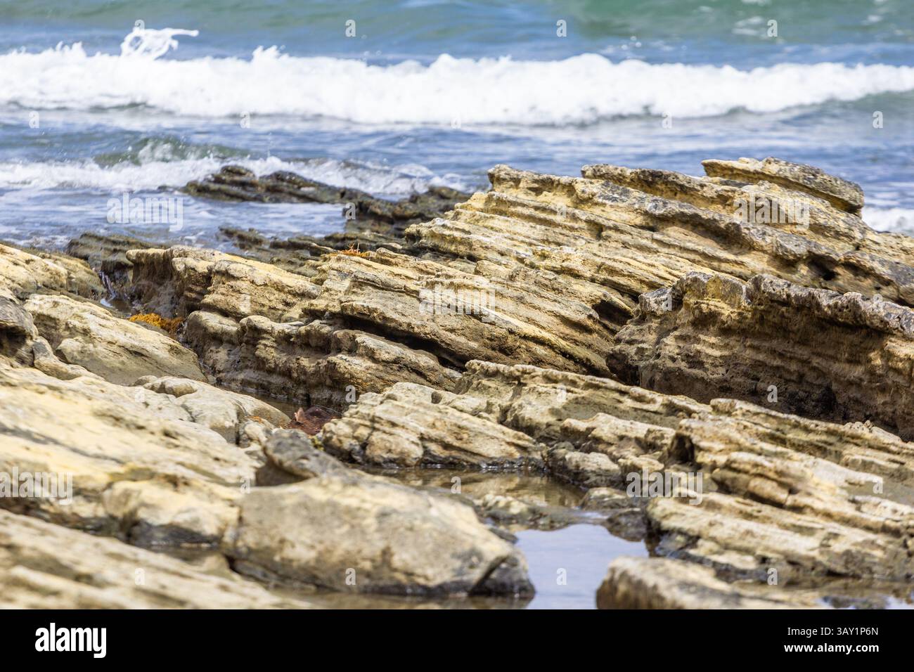 La formazione Afga Wave Rock a Tangalan, Aklan, Filippine, presenta strati di corallo e calcare scolpiti dalle onde, una meravigliosa meraviglia geologica costiera Foto Stock