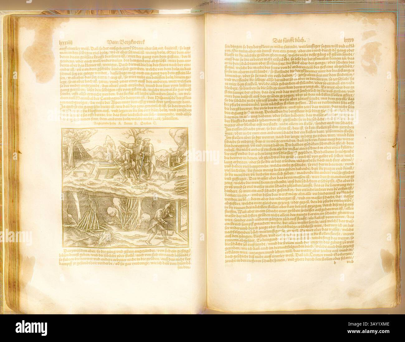 Un libro aperto con testo ornato e un'intricata illustrazione raffigurante una scena con figure impegnate in varie attività, circondate da elementi e strutture naturali. Le pagine sono invecchiate, con una calda tonalità beige lungo i bordi., fuoco nella fossa, legna da ardere è impilata nella fossa e incendiata in modo che la roccia più solida possa essere riscaldata e poi estratta più facilmente. Woodcut, p. 84, (Das fünftft Buch), Manuel, Hand Rudolf (graveur sur bois), 1557, Gregorius agricola: Vom Bergkwerck XII Bücher darinn alle Empter, Instument, Gezeuge unnd alles zu disem handel gehörig, mitt schönen figuren, vorbil Foto Stock