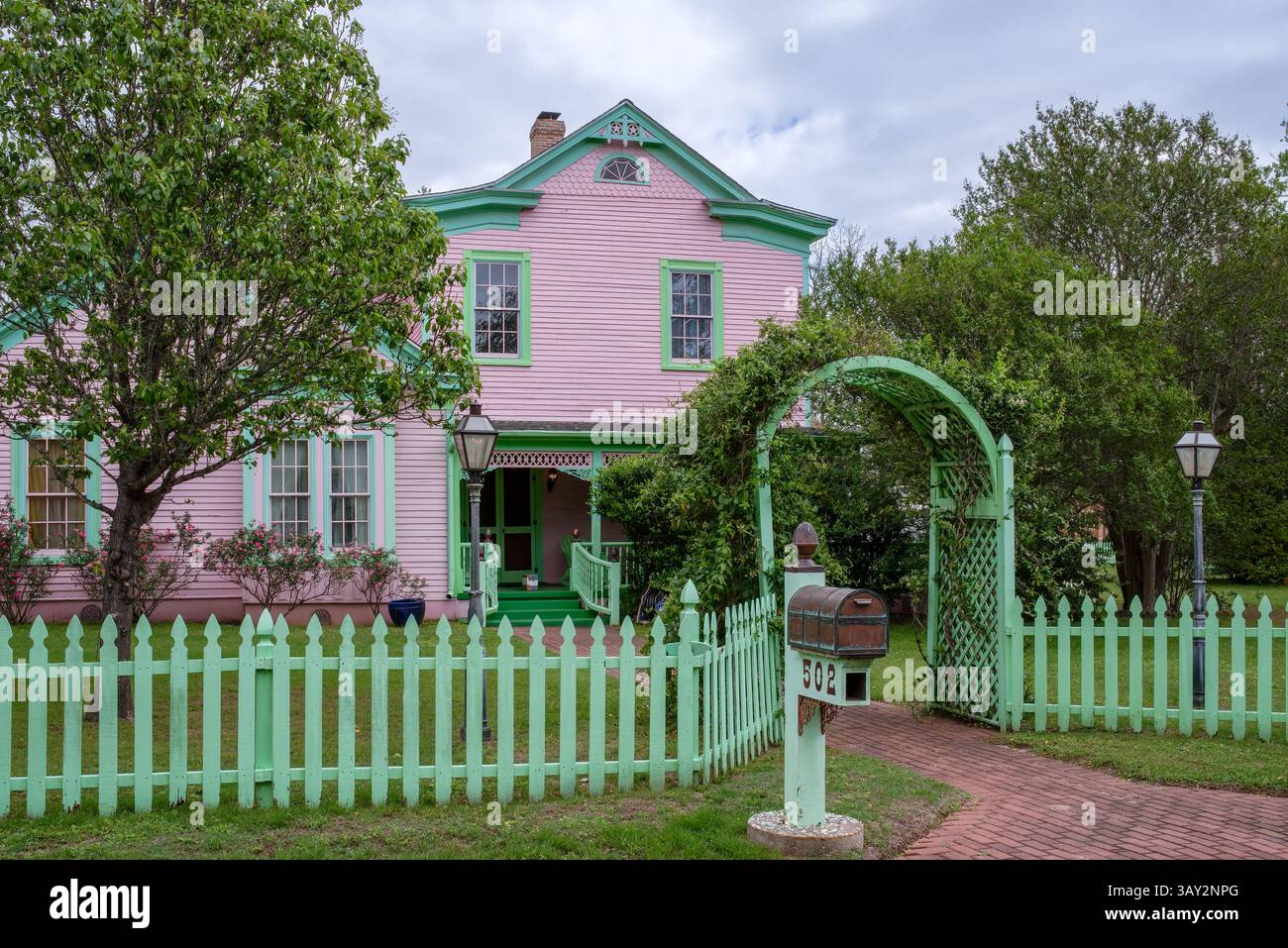 Casa rosa a due piani con finiture verdi e recinzione verde, Smithville, Bastrop County, Tennessee, Stati Uniti. Foto Stock
