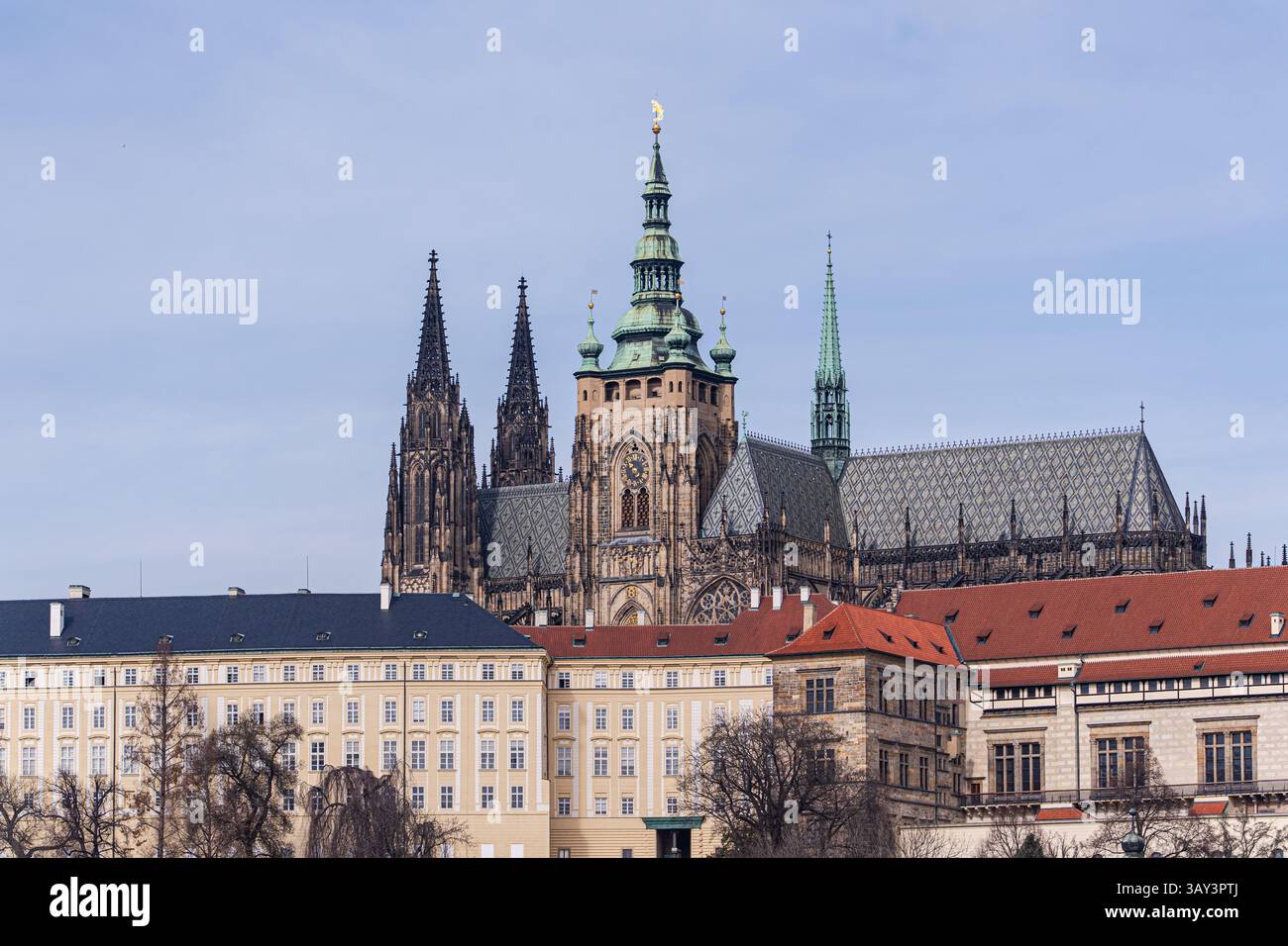Un'immagine classica che cattura la cattedrale di San Vito e il palazzo storico circostante di Praga, adagiato su un sereno cielo blu. Foto Stock