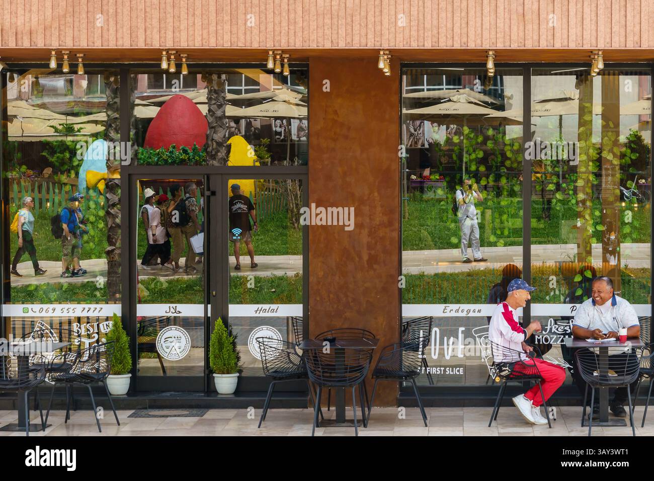 Maggio 2024. Durazzo, Albania. Due uomini che ridono mentre preparano il caffè fuori da un bar. Foto: © Simon Grosset Foto Stock