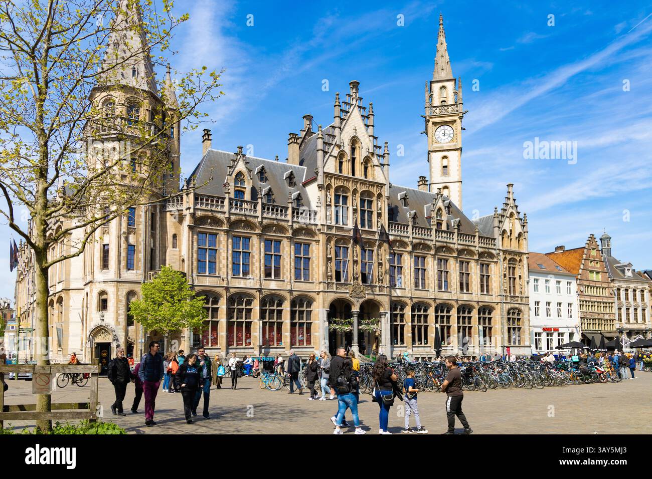 Gand, Belgio - 30/04/2023: Lo storico edificio dell'ex ufficio postale si affaccia sulla trafficata piazza Korenmarkt a Gand, Belgio, piena di pedoni Foto Stock