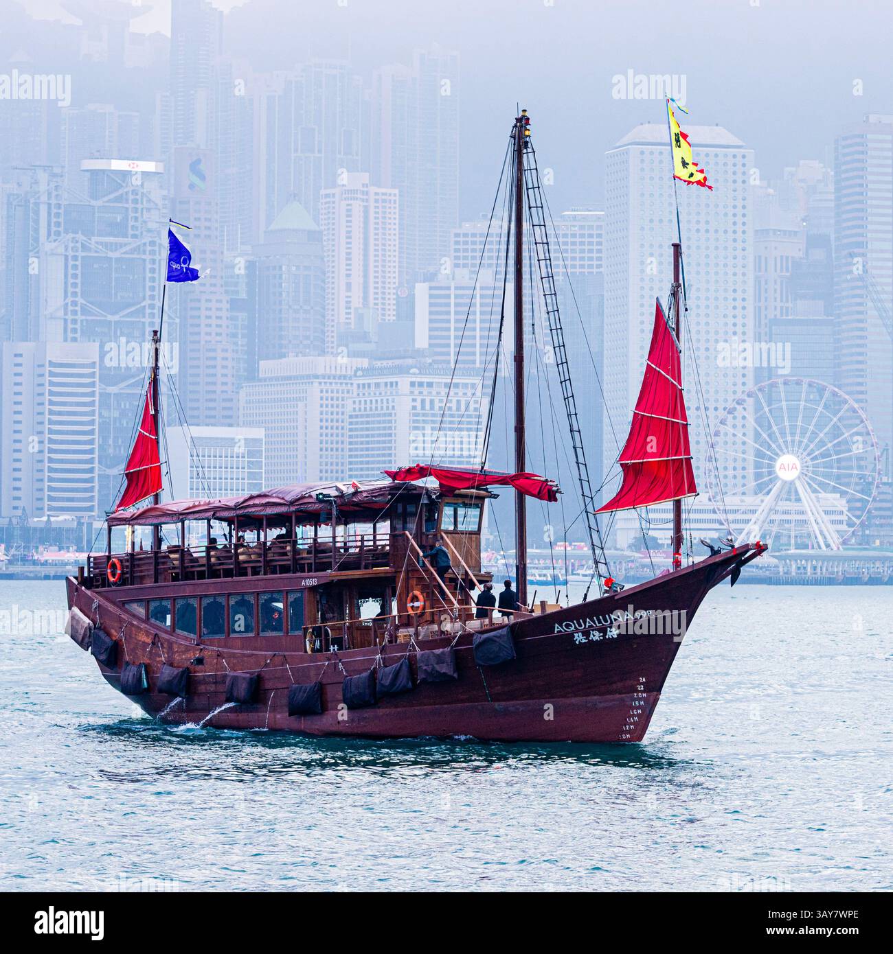 La vela rossa Aqualuna Chines giunca nel porto di Victoria vista da Tsim Sha Tsui, Kowloon, Hong Kong, Cina Foto Stock