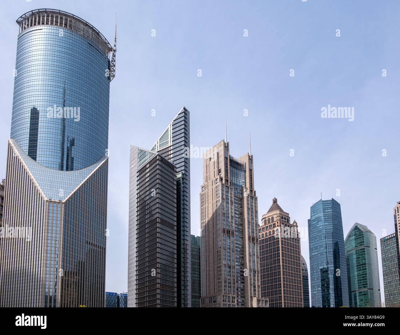 Shanghai, Cina, edifici cittadini. Grattacieli moderni contro il cielo blu, alte torri di uffici in acciaio e vetro Foto Stock