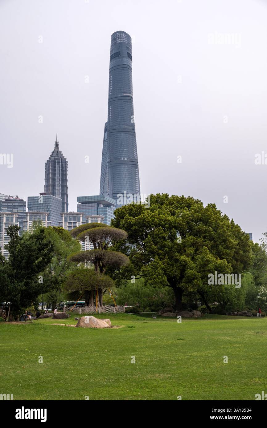 Alti edifici della città di Shanghai contro il cielo nuvoloso, Cina. Grattacieli commerciali e residenziali e parco cittadino Foto Stock