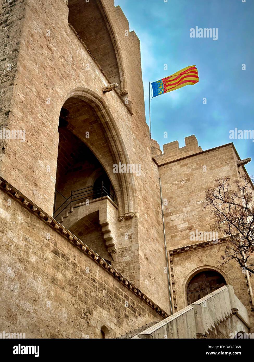 Una fortezza storica con una bandiera sventolante, situata nel cuore di Valencia, Spagna. - Immagine stock catturata con smartphone