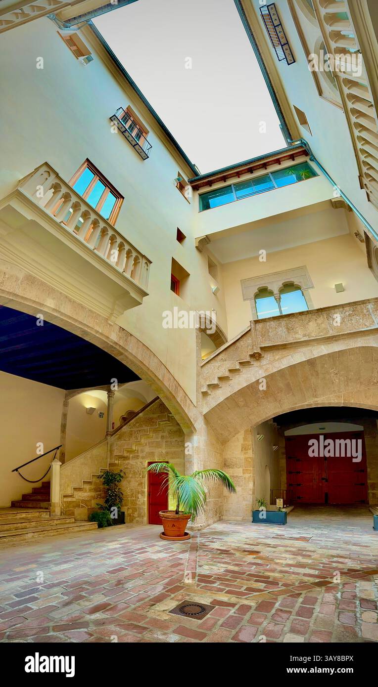 Un tradizionale cortile spagnolo caratterizzato da eleganti archi in pietra e dalla classica architettura mediterranea. - Immagine stock catturata con smartphone