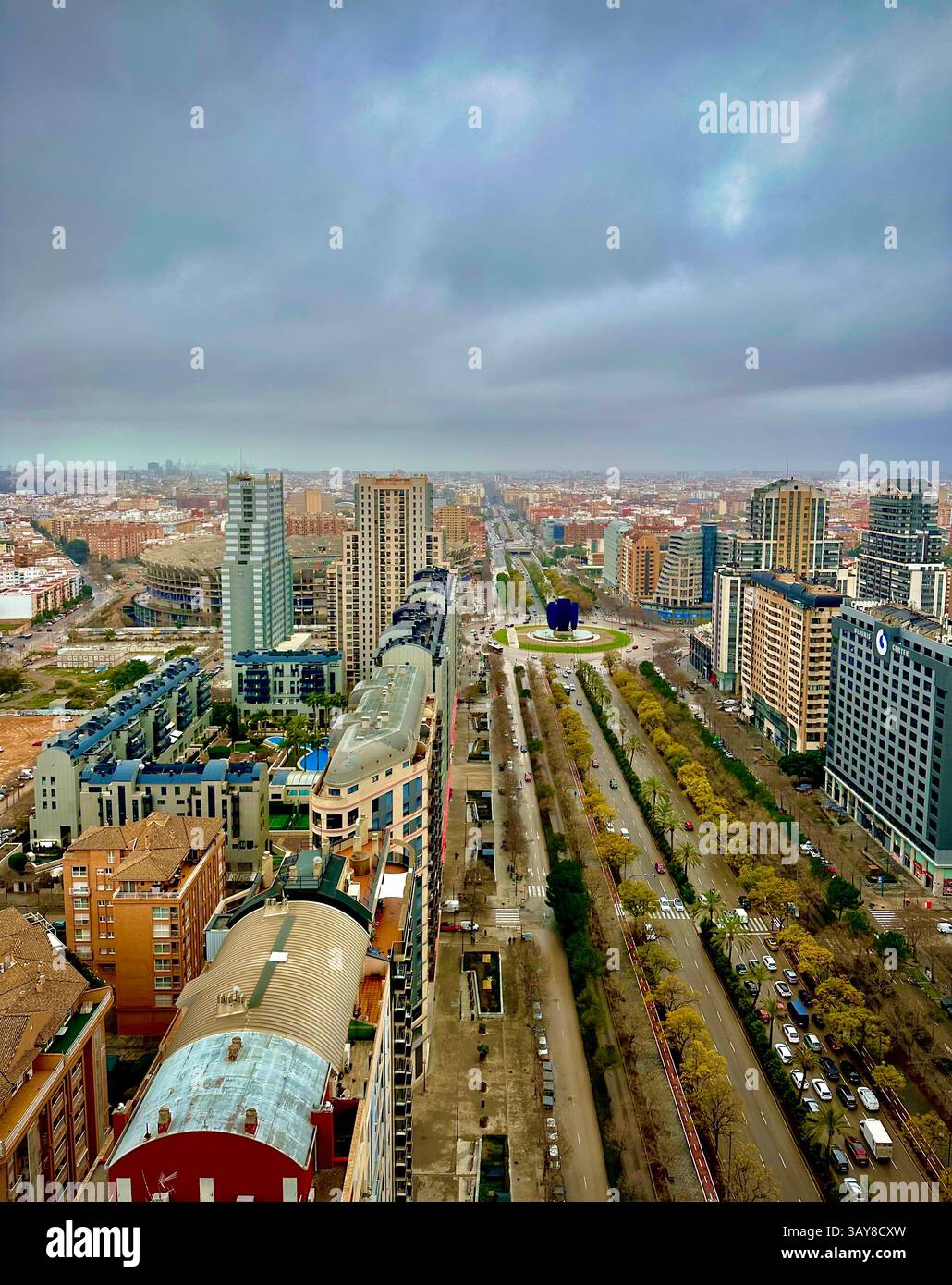 Un viale simmetrico fiancheggiato da alti edifici, che illustrano la pianificazione urbana di Valencia. - Immagine stock catturata con smartphone
