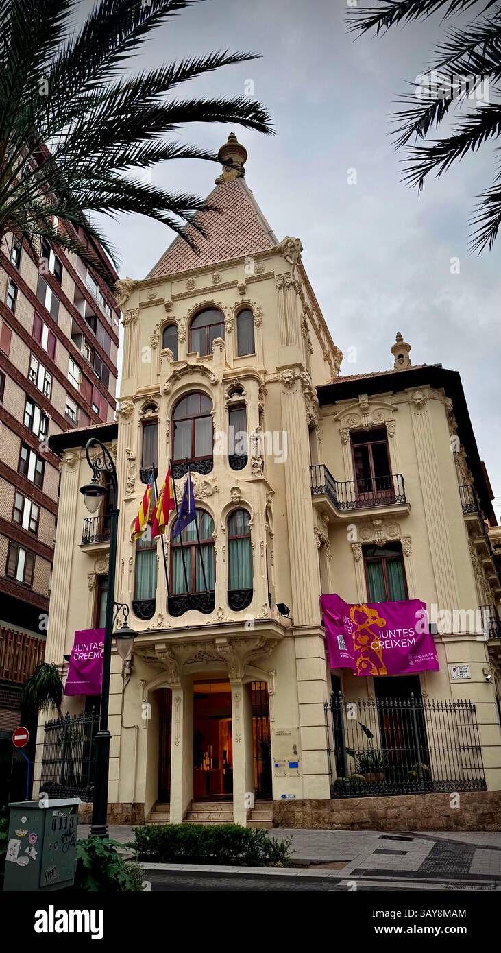 Edificio storico splendidamente conservato con una facciata elaborata e bandiere europee esposte all'entrata. Lo stile architettonico è intrigante - Immagine stock catturata con smartphone