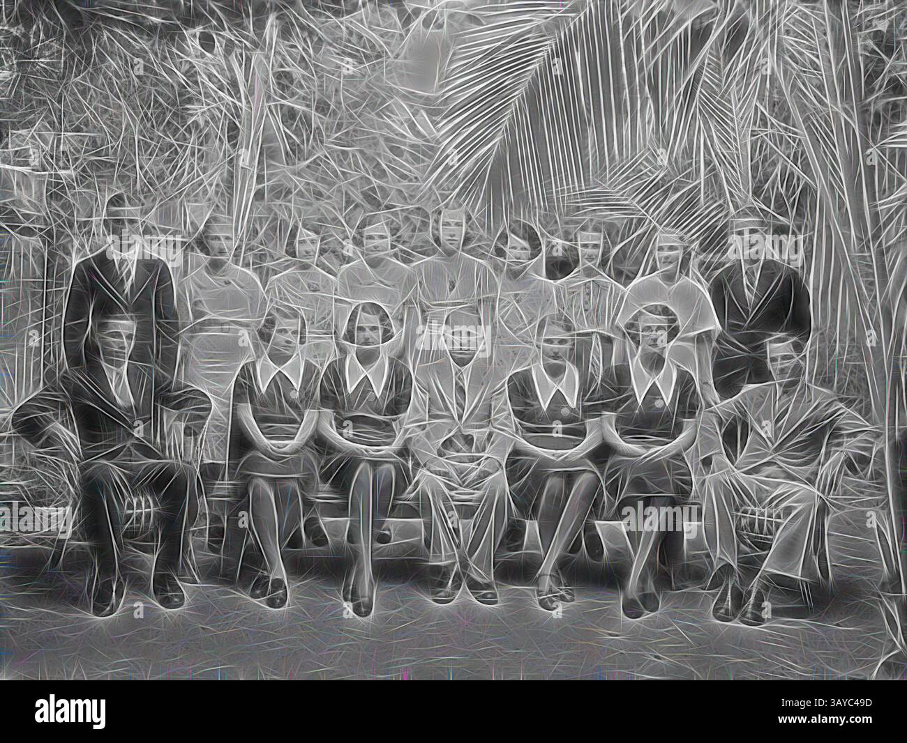 Un grande gruppo di uomini e donne è riunito all'aperto, organizzato in una posa formale. La scena è caratterizzata da una vegetazione lussureggiante sullo sfondo, con individui vestiti in abiti da inizio a metà del XX secolo. Le espressioni vanno dal serio al rilassato, creando un senso di cameratismo tra il gruppo., negative, staff Group Portrait, Kodak Branch, Townsville, QLD, anni '1930, film in bianco e nero negativo con un ritratto di gruppo del personale presso la filiale Kodak Australasia Pty Ltd e laboratorio di lavorazione in giornata a Flinders St, Townsville, Queensland, negli anni '1930 Questo negozio Kodak lo era Foto Stock