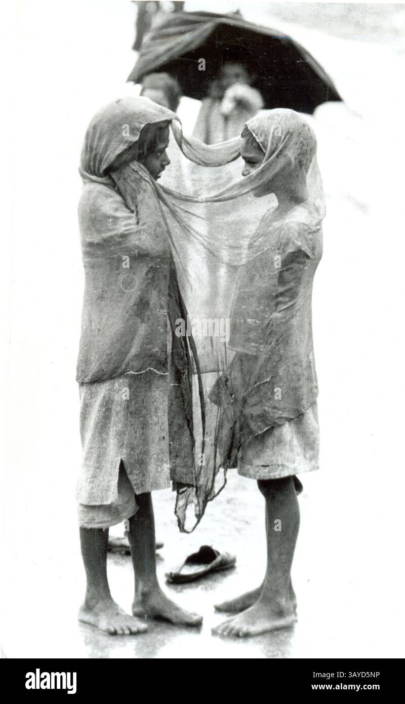 13 luglio 2010 - nuova Delhi, India - due ragazze si trovano sotto la pioggia sotto un panno durante la stagione dei monsoni. Il monsone dura in India circa tre mesi da luglio a settembre. (Immagine di credito: © TC Malhotra/ZUMApress.com) Foto Stock