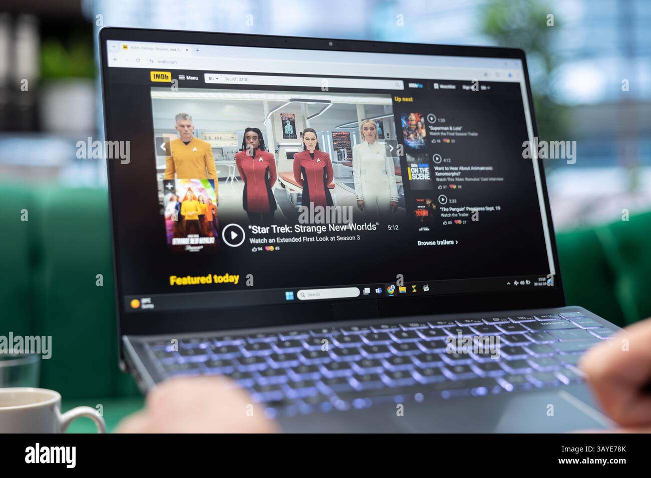 Bucarest, Romania - 30 luglio 2024 - persona alla ricerca di metascore e rating nella pagina web IMDb, cinefilo che guarda un film dopo aver letto la recensione della critica. Ventola che controlla il pezzo fuso. Foto Stock