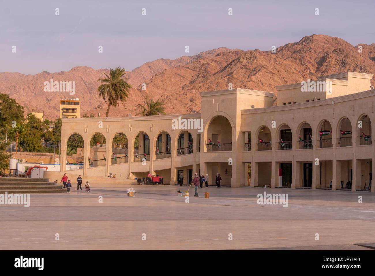 Un edificio dall'architettura tradizionale in Arab Revolt Plaza, città di Aqaba, Giordania, con montagne sullo sfondo. Foto Stock