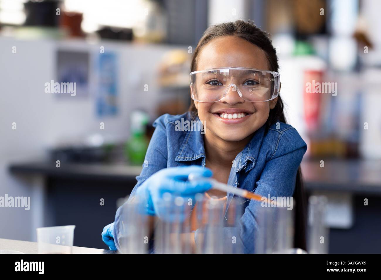 Guanti blu per miscelazione di liquidi per bambini con provette per pipette per test in laboratorio scientifico Foto Stock