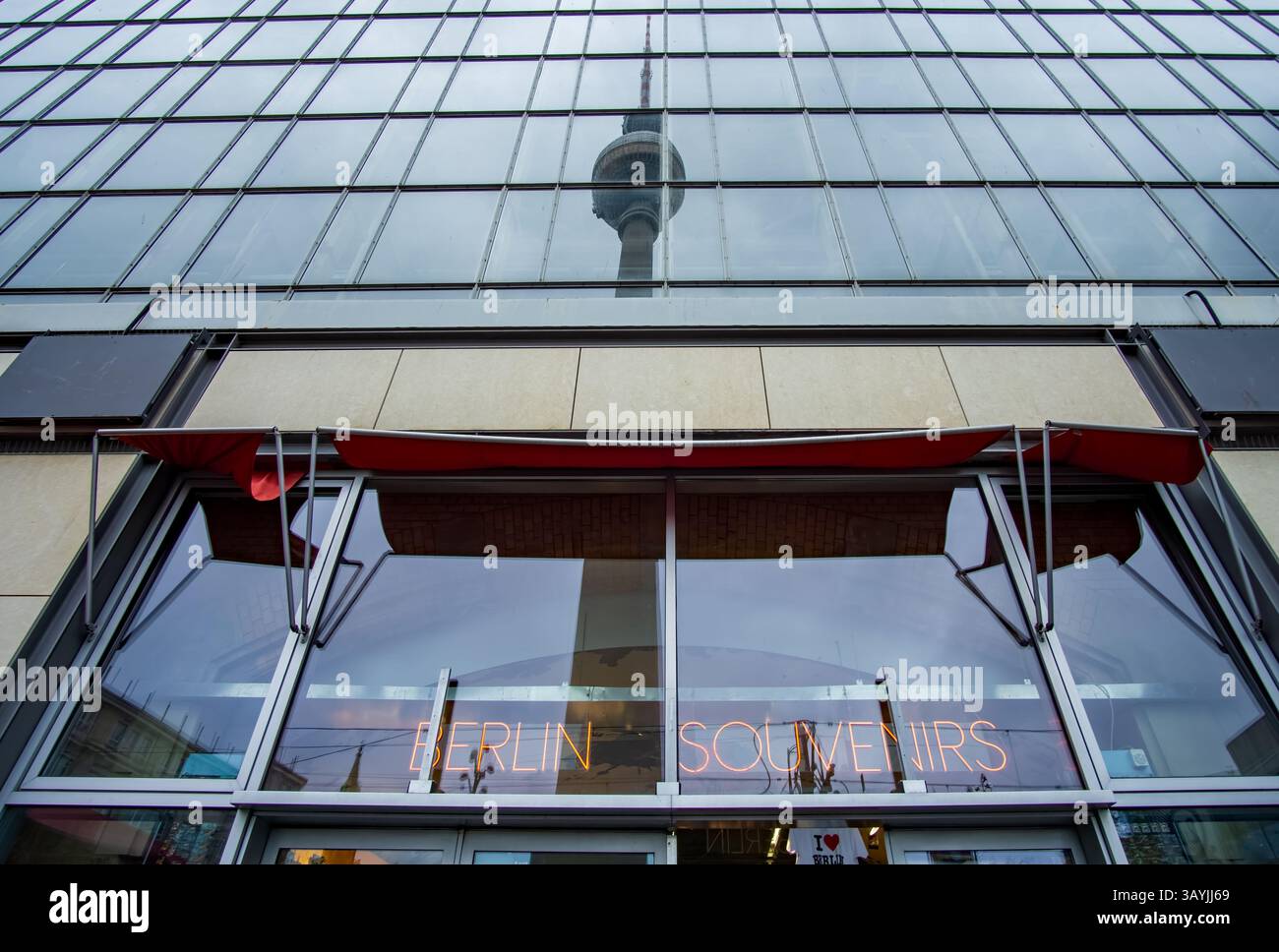 Torre della televisione di Berlino riflessa nel bicchiere di un negozio di souvenir ad Alexanderplatz, con l'insegna al neon "Berlin Souvenirs", Germania. Foto Stock