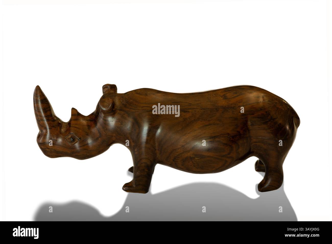 Un tradizionale rinoceronte africano intagliato a mano in legno isolato su uno sfondo bianco con un'ombra Foto Stock