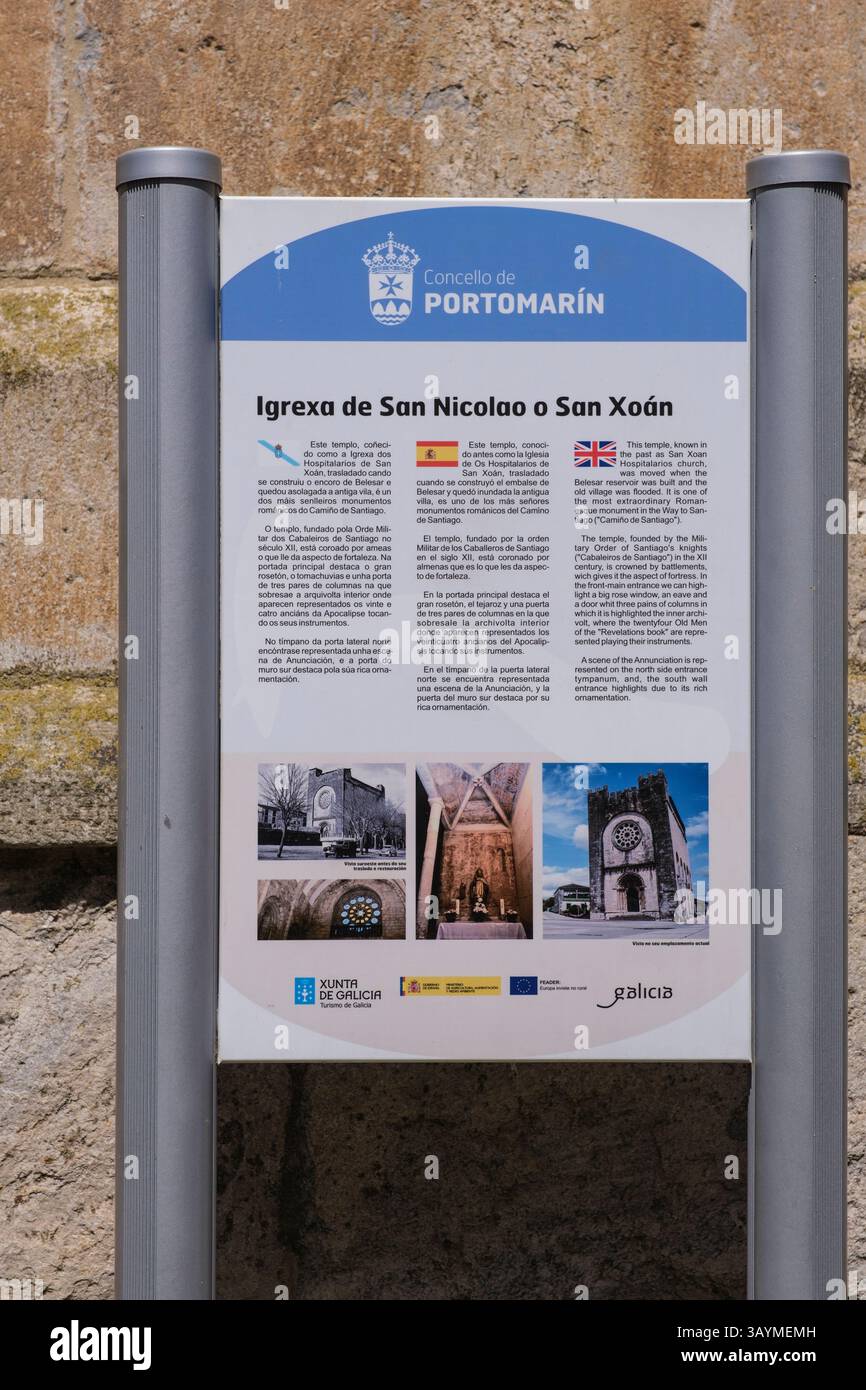 Spagna, Portomarin, Galizia. Insegna informativa trilingue - inglese, spagnolo e Gallego - - sulla Chiesa di San Nicolas (San Juan, San Xoan). Foto Stock