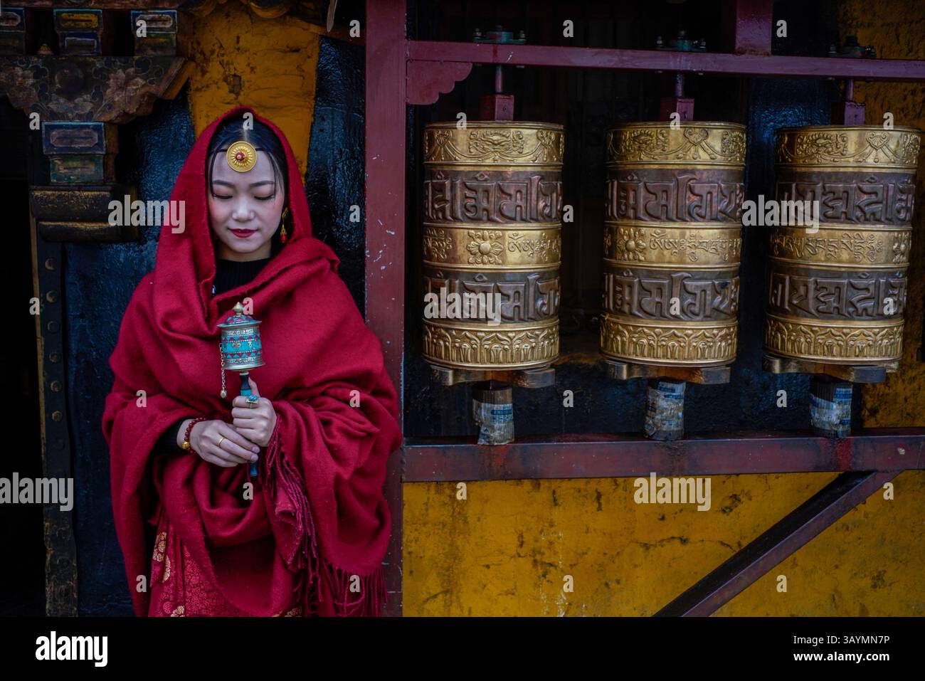 I giovani turisti cinesi vestiti con abiti tradizionali stilizzati posano per le fotografie mentre esplorano le strade storiche di Lhasa, in Tibet. Il loro garme Foto Stock