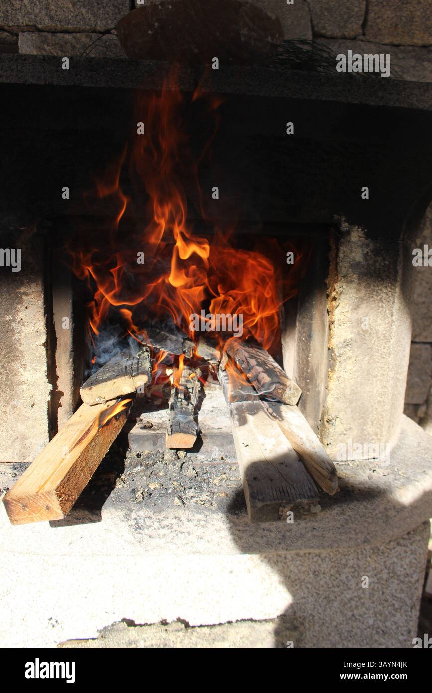 Legna da ardere in un forno rustico in pietra sotto la luce del sole - Ponte da barca - Portogallo Foto Stock