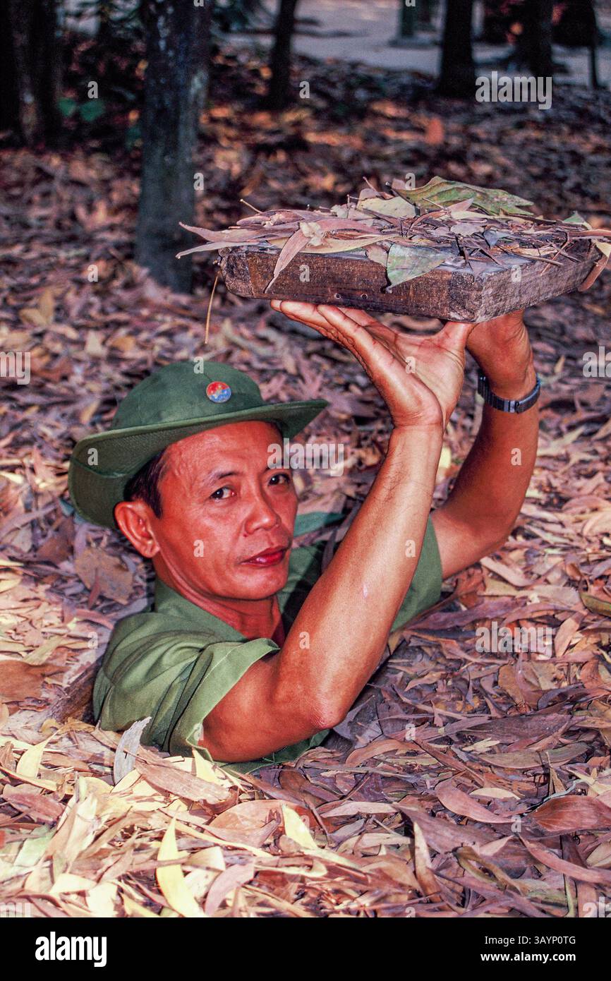 La guida mostra ai visitatori un ingresso nascosto ai tunnel di Cu chi, vicino alla città di ho chi Minh, Vietnam Foto Stock