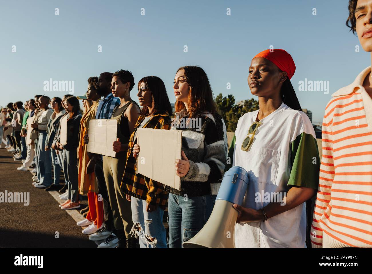 Un gruppo socialmente attivo di individui diversi prende posizione contro l'ingiustizia, impegnato in una protesta pubblica che dimostra unità e solidarietà per una CA Foto Stock