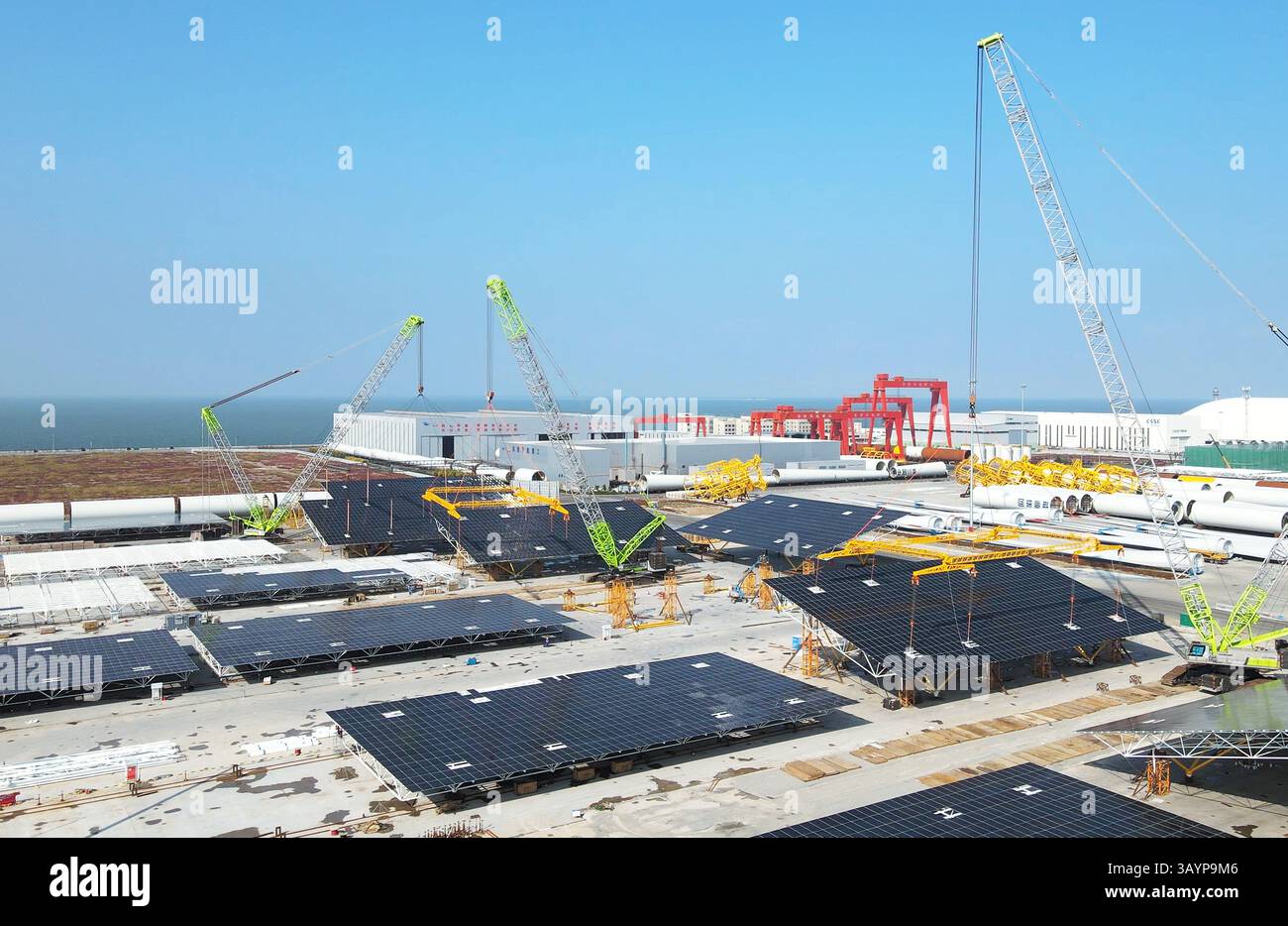 Assemblaggio di pannelli solari offshore al porto - Logistica e installazione di energie rinnovabili Foto Stock