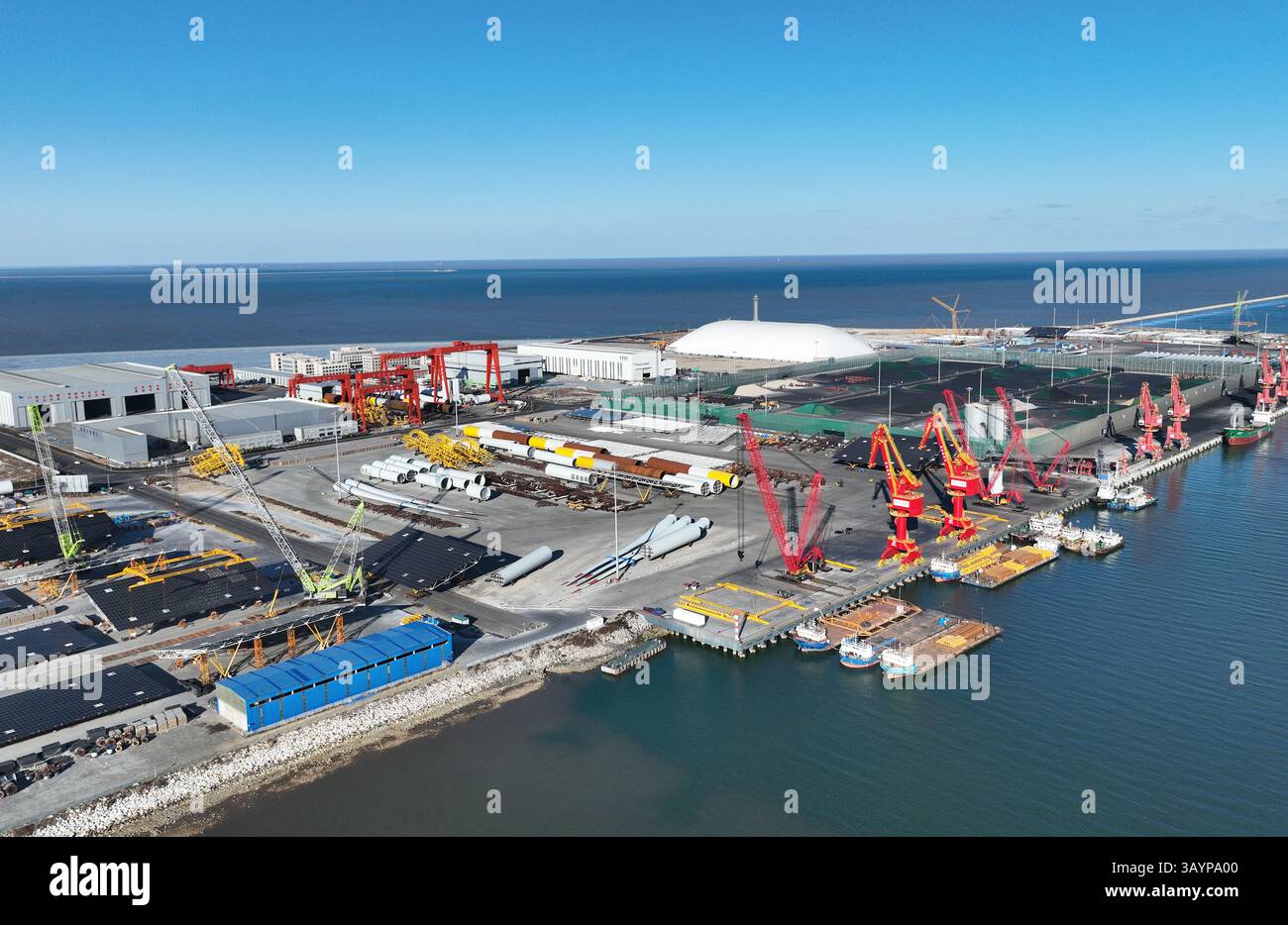 La vivace attività marittima si svolge in un vivace porto durante una giornata di blu chiaro in un centro industriale Foto Stock