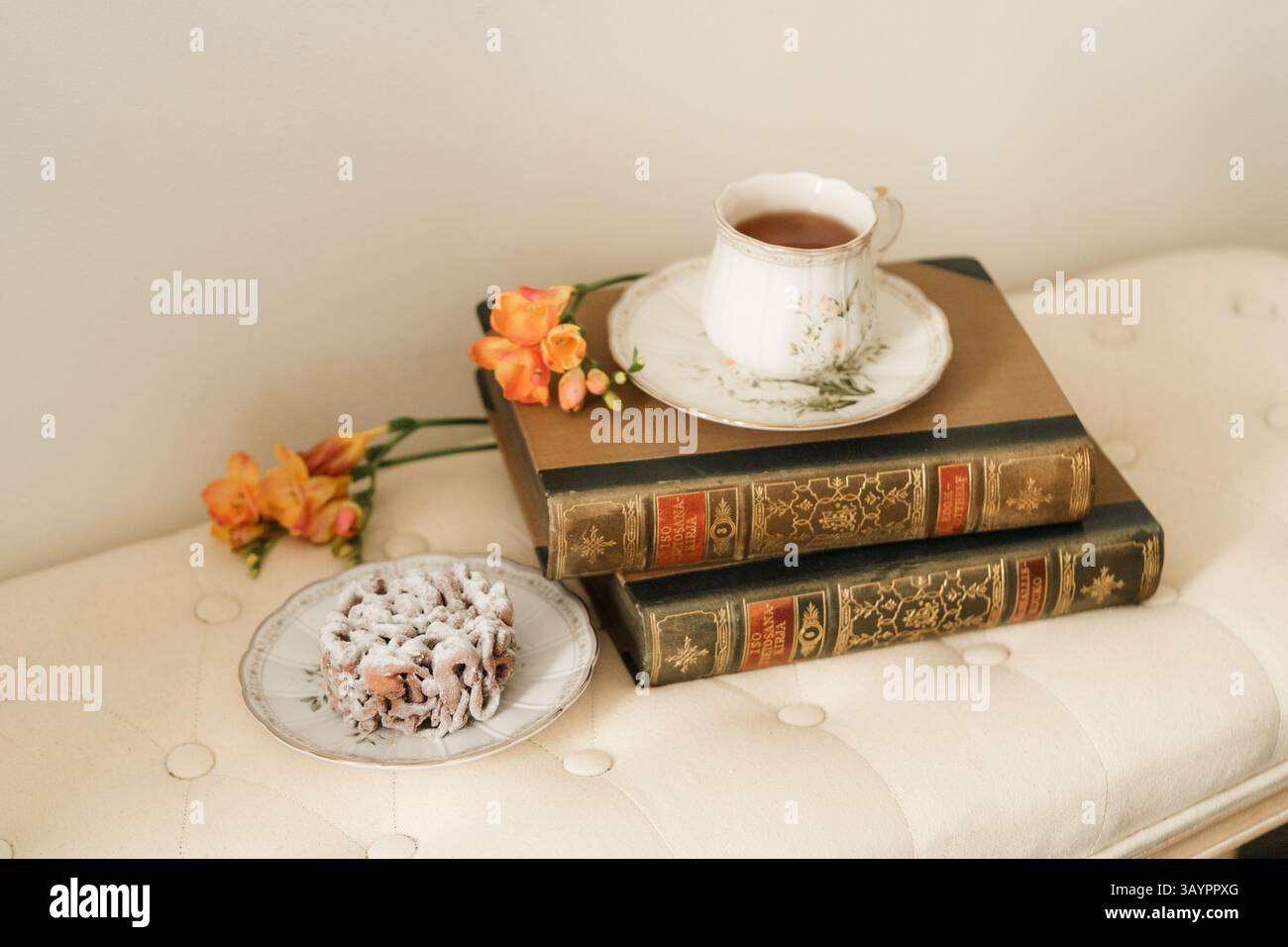 Tazza da caffè, torta a imbuto e libri sul tavolo. Stile vintage. Foto Stock