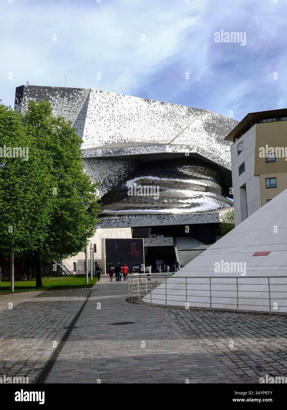 Persone che entrano nella sede della Filarmonica di Parigi al complesso Cité de la Musique a Parc de la Villette, Parigi, Francia. Foto Stock