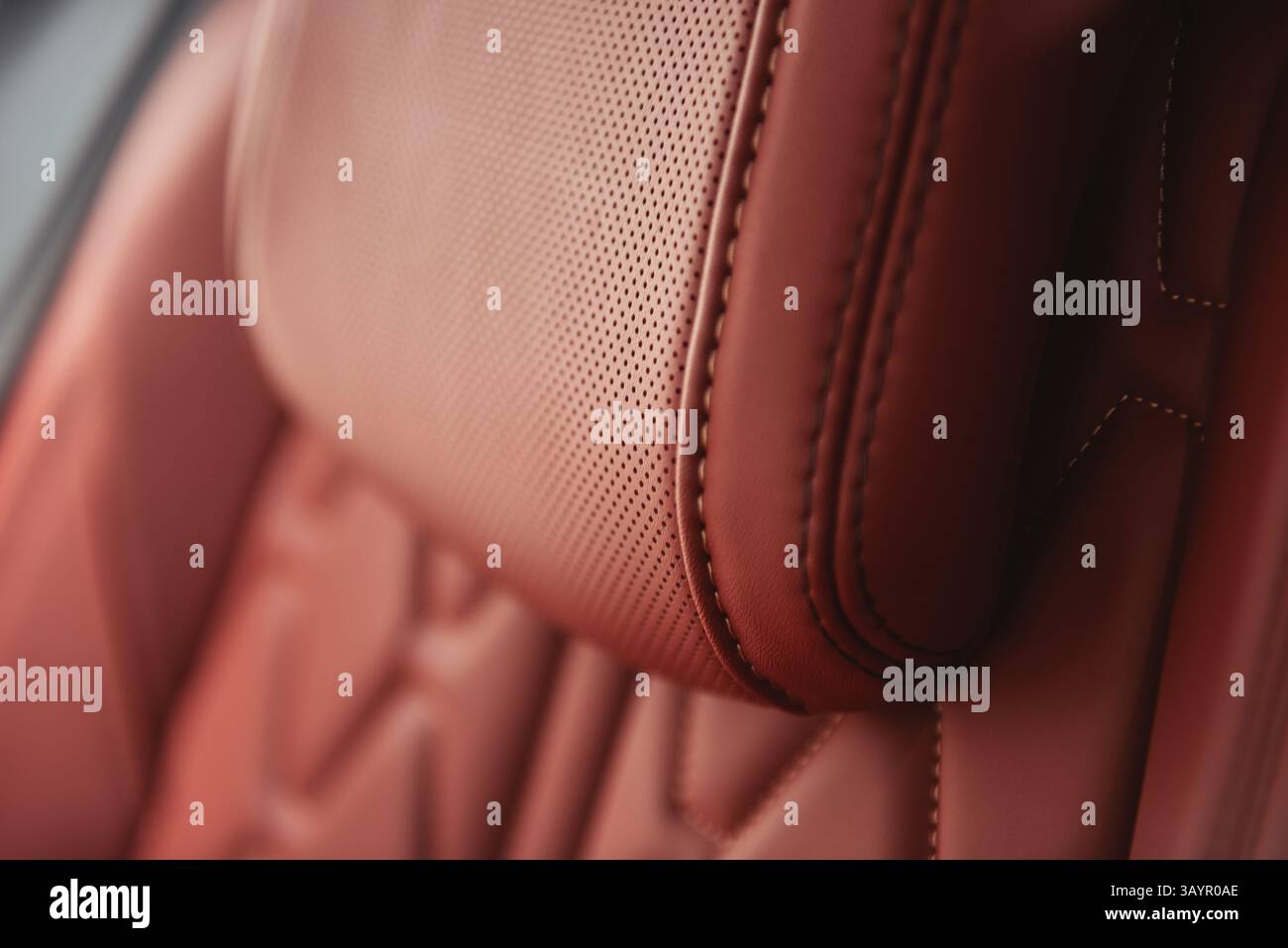 Poggiatesta del sedile in pelle per auto - Vista ravvicinata. Sedile in pelle rosso argilla in un'auto moderna - attenzione selettiva. Foto Stock