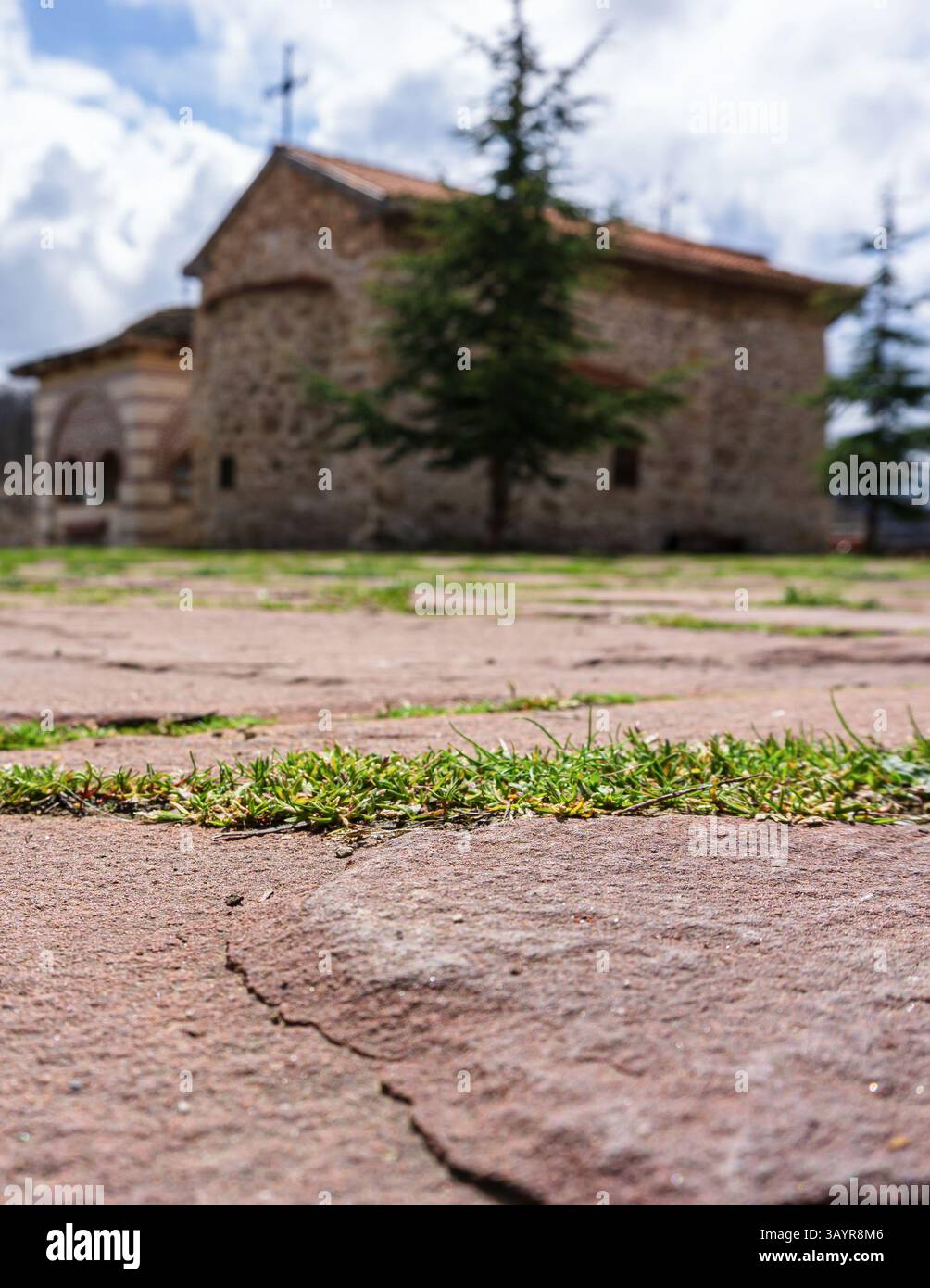 Un vecchio sentiero in pietra che conduce verso una chiesa sfocata sullo sfondo Foto Stock