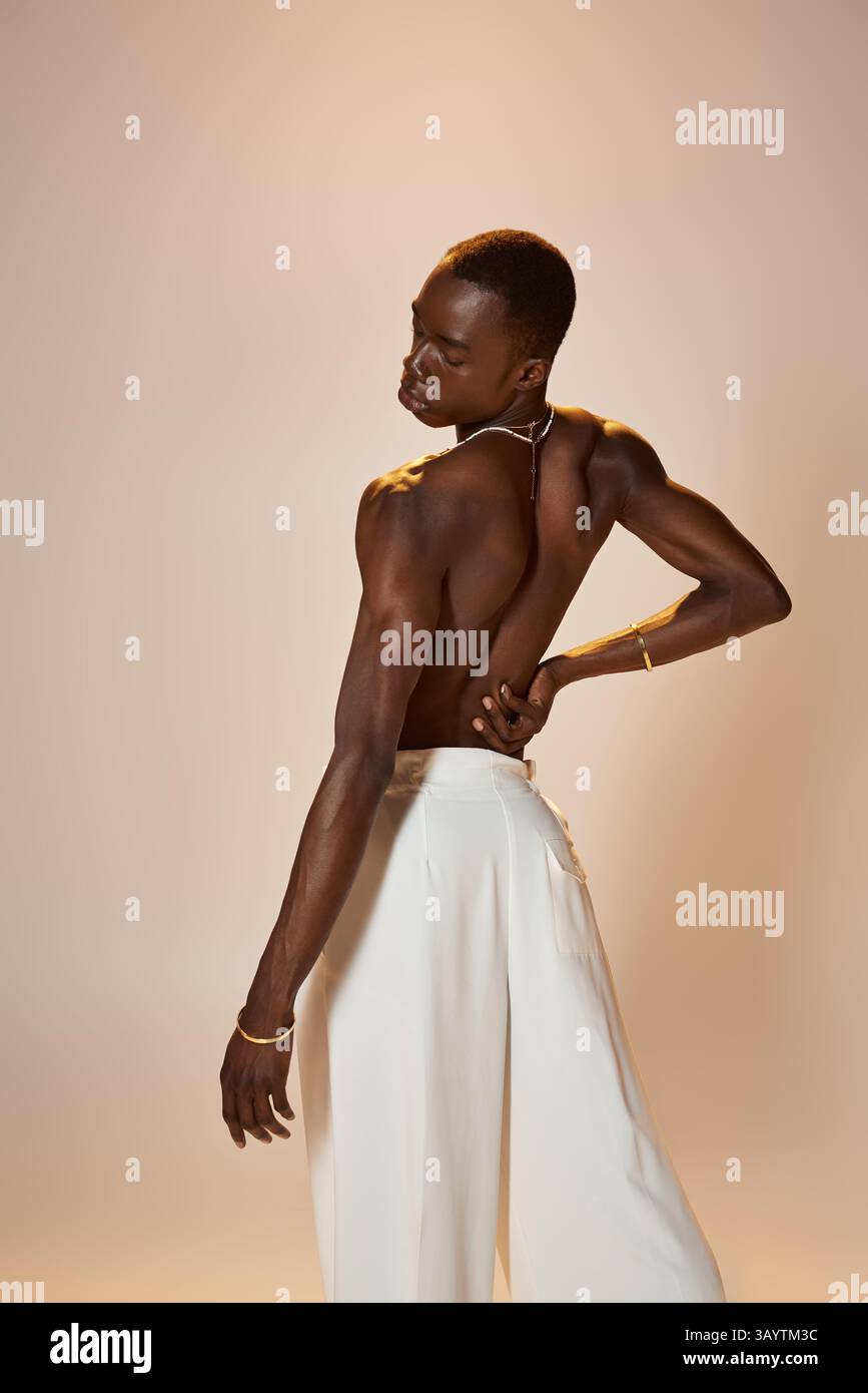 Un giovane afro-americano modella un vestito straordinario, che irradia fiducia ed energia vibrante. Foto Stock