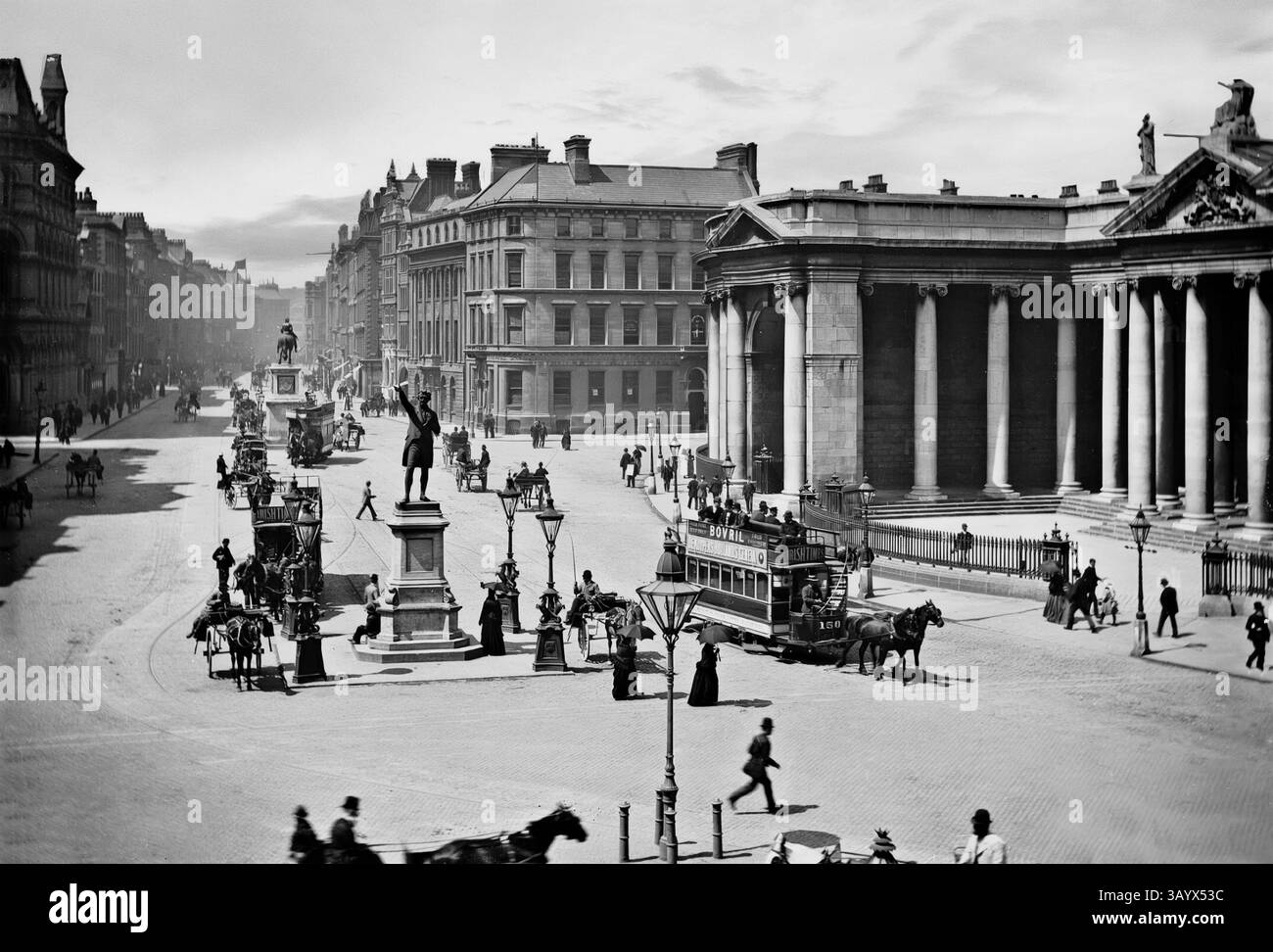 Una vista della fine del XIX secolo della statua di Henry Grattan (1746-1820), un politico e avvocato irlandese che fece campagna per la libertà legislativa per il Parlamento irlandese alla fine del XVIII secolo dalla Gran Bretagna. Un superbo oratore, chiese che all'Irlanda venisse concesso il suo legittimo status di nazione indipendente. Con persone, veicoli trainati da cavalli e tram elettrici di nuova introduzione. La sinistra è la banca d'Irlanda - una volta sede del Parlamento irlandese. Sulla destra c'è Regent House, che funge da ingresso centrale al campus del Trinity College di Dublino, Irlanda. Foto Stock