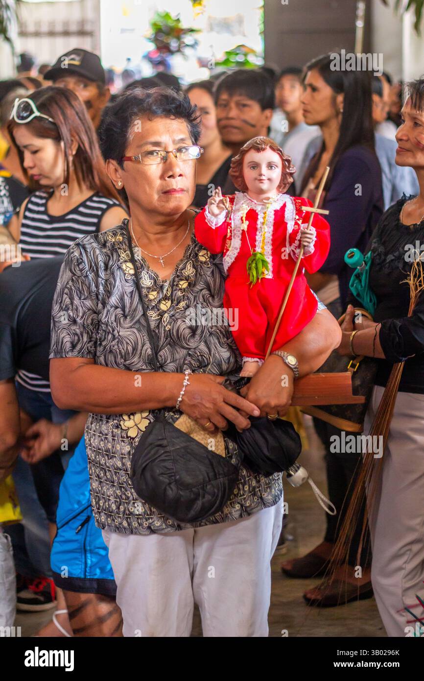 I devoti filippini hanno un'immagine dello sto Niño durante il Festival Ibajay ATI-ATI di Aklan, una vibrante festa religiosa locale nelle Filippine Foto Stock