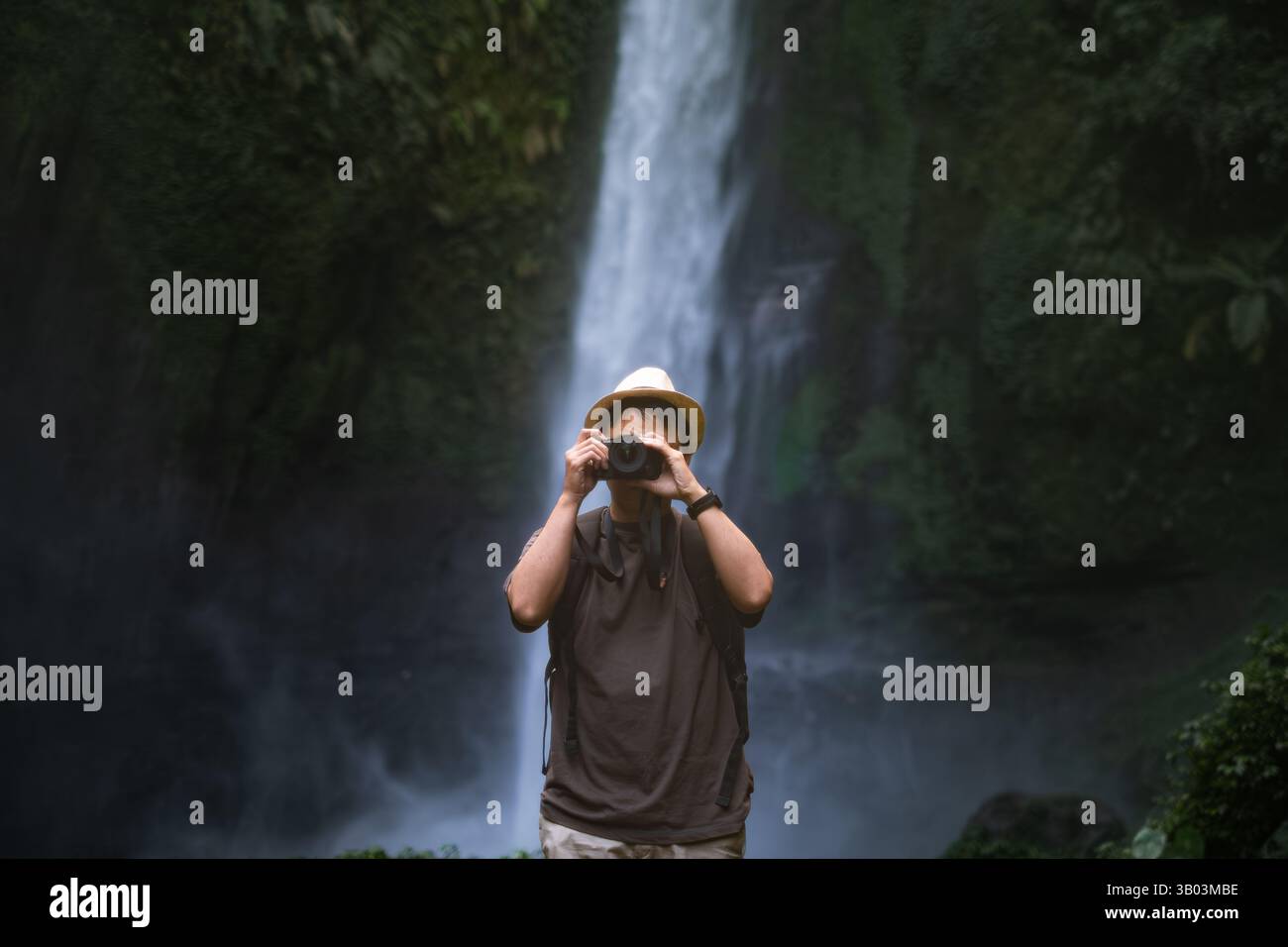 Un viaggiatore scatta foto con la macchina fotografica alla cascata Foto Stock