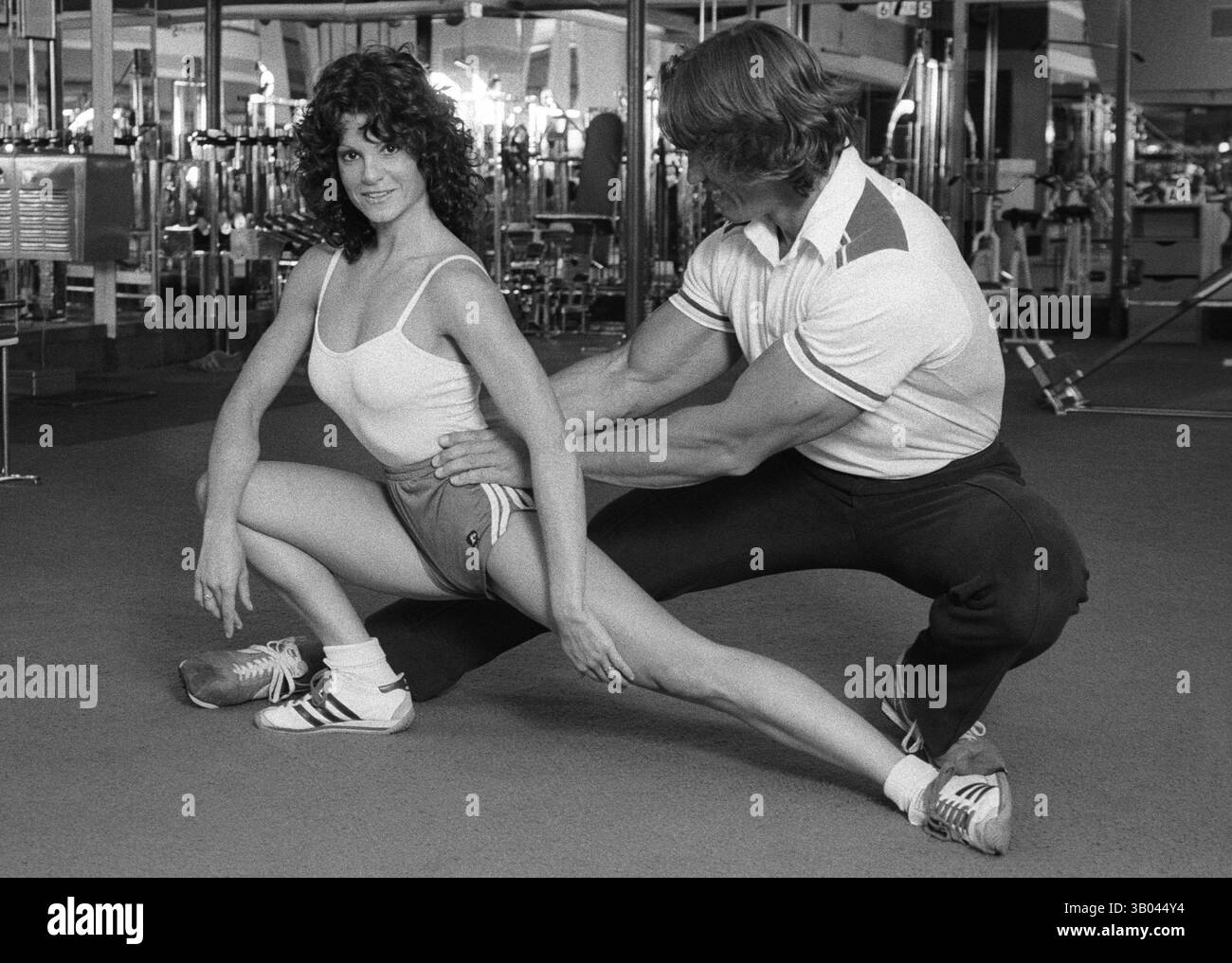 25 marzo 1979; Los Angeles, CA, Stati Uniti; il bodybuilder professionista ARNOLD SCHWARZENEGGER dimostra un esercizio di stretching con la campionessa del mondo di bodybuilding femminile LISA LYON, durante un servizio fotografico. Nato in un piccolo villaggio in Austria, Arnold iniziò ad allenarsi con i pesi in giovane età e presto raggiunse la vetta come campione di bodybuilding. La sua pausa nella recitazione è arrivata nel film di successo del 1982 "Conan the Barbarian". Da Conan, Arnold ha mantenuto una lunga carriera come attore. Arnold divenne anche attivo nella politica degli Stati Uniti all'inizio degli anni '80 e da allora è stato eletto governatore della California B. Foto Stock