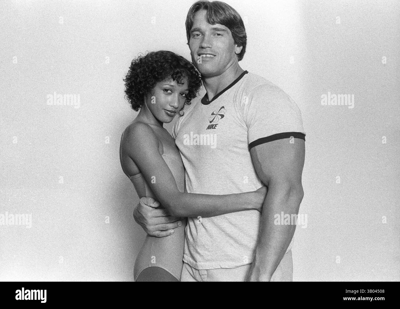 24 marzo 1979; Los Angeles, CALIFORNIA, USA - il bodybuilder professionista ARNOLD SCHWARZENEGGER posa con la modella di fitness, Yvette, mentre la tiene vicino con un braccio durante un servizio fotografico. Nato in un piccolo villaggio in Austria, Arnold iniziò ad allenarsi con i pesi in giovane età e presto raggiunse la vetta come campione di bodybuilding. La sua pausa nella recitazione è arrivata nel film di successo del 1982 "Conan the Barbarian". Da Conan, Arnold ha mantenuto una lunga carriera come attore. Arnold divenne anche attivo nella politica degli Stati Uniti all'inizio degli anni '80 e da allora è stato eletto governatore della California per mezzo di un contro Foto Stock