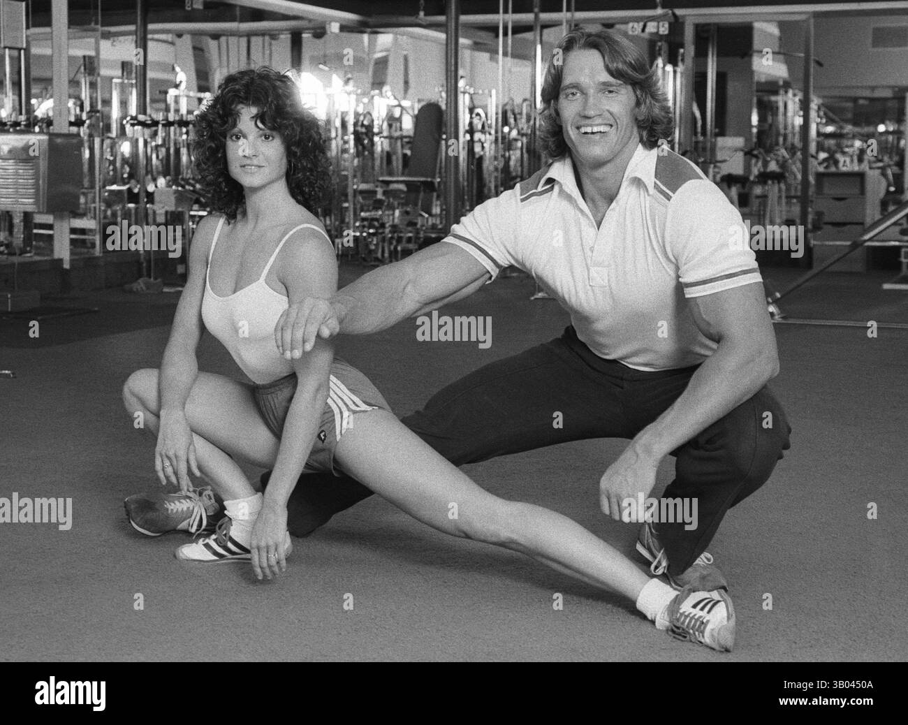 25 marzo 1979; Los Angeles, CA, Stati Uniti; il bodybuilder professionista ARNOLD SCHWARZENEGGER dimostra un esercizio di stretching con la campionessa del mondo di bodybuilding femminile LISA LYON, durante un servizio fotografico. Nato in un piccolo villaggio in Austria, Arnold iniziò ad allenarsi con i pesi in giovane età e presto raggiunse la vetta come campione di bodybuilding. La sua pausa nella recitazione è arrivata nel film di successo del 1982 "Conan the Barbarian". Da Conan, Arnold ha mantenuto una lunga carriera come attore. Arnold divenne anche attivo nella politica degli Stati Uniti all'inizio degli anni '80 e da allora è stato eletto governatore della California B. Foto Stock