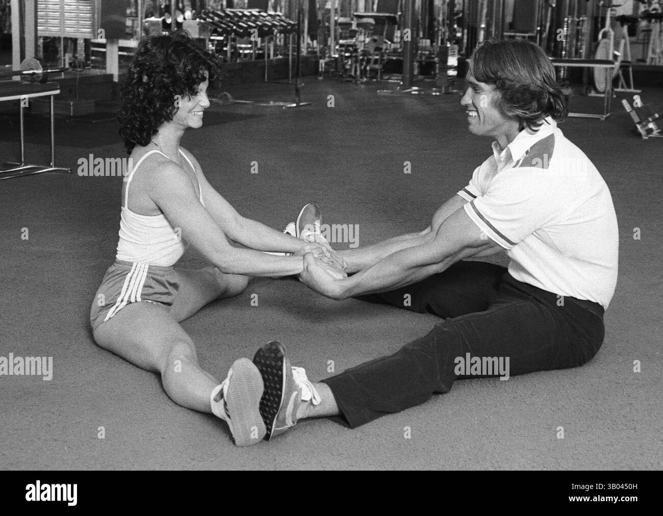 25 marzo 1979; Los Angeles, CA, Stati Uniti; il bodybuilder professionista ARNOLD SCHWARZENEGGER dimostra un esercizio di stretching con la campionessa del mondo di bodybuilding femminile, LISA LYON, durante un servizio fotografico. Nato in un piccolo villaggio in Austria, Arnold iniziò ad allenarsi con i pesi in giovane età e presto raggiunse la vetta come campione di bodybuilding. La sua pausa nella recitazione è arrivata nel film di successo del 1982 "Conan the Barbarian". Da Conan, Arnold ha mantenuto una lunga carriera come attore. Arnold divenne anche attivo nella politica degli Stati Uniti all'inizio degli anni '80 e da allora è stato eletto governatore della California Foto Stock