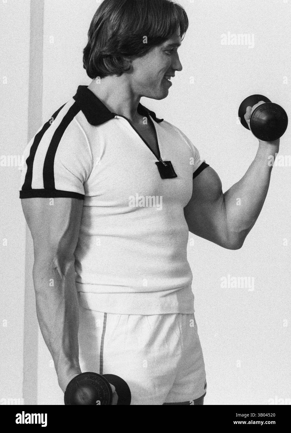 24 marzo 1979; Los Angeles, CA, USA - il bodybuilder professionista ARNOLD SCHWARZENEGGER dimostra un esercizio di peso per un servizio fotografico di libri. Nato in un piccolo villaggio in Austria, Arnold iniziò ad allenarsi con i pesi in giovane età e presto raggiunse la vetta come campione di bodybuilding. La sua pausa nella recitazione è arrivata nel film di successo del 1982 "Conan the Barbarian". Da Conan, Arnold ha mantenuto una lunga carriera come attore. Arnold divenne anche attivo nella politica degli Stati Uniti all'inizio degli anni '80 e da allora è stato votato come governatore della California attraverso un controverso richiamo dell'ex governatore Gray da Foto Stock