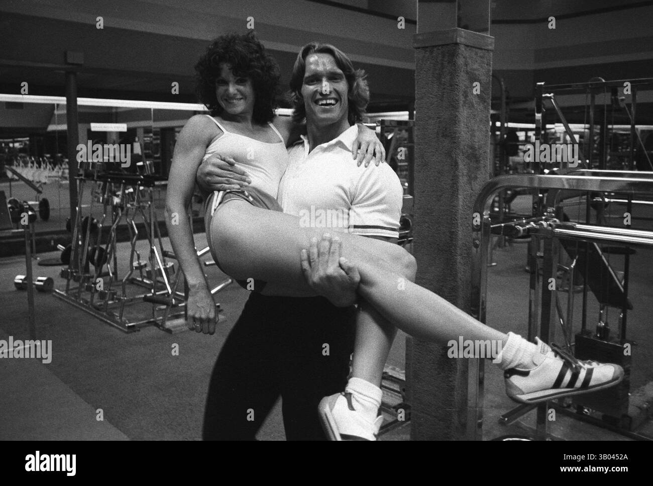 25 marzo 1979; Los Angeles, CA, Stati Uniti; il bodybuilder professionista ARNOLD SCHWARZENEGGER tiene tra le braccia la campionessa mondiale di bodybuilding femminile LISA LYON durante un servizio fotografico. Nato in un piccolo villaggio in Austria, Arnold iniziò ad allenarsi con i pesi in giovane età e presto raggiunse la vetta come campione di bodybuilding. La sua pausa nella recitazione è arrivata nel film di successo del 1982 "Conan the Barbarian". Da Conan, Arnold ha mantenuto una lunga carriera come attore. Arnold divenne anche attivo nella politica degli Stati Uniti all'inizio degli anni '80 e da allora è stato eletto governatore della California per via di un controverso Foto Stock
