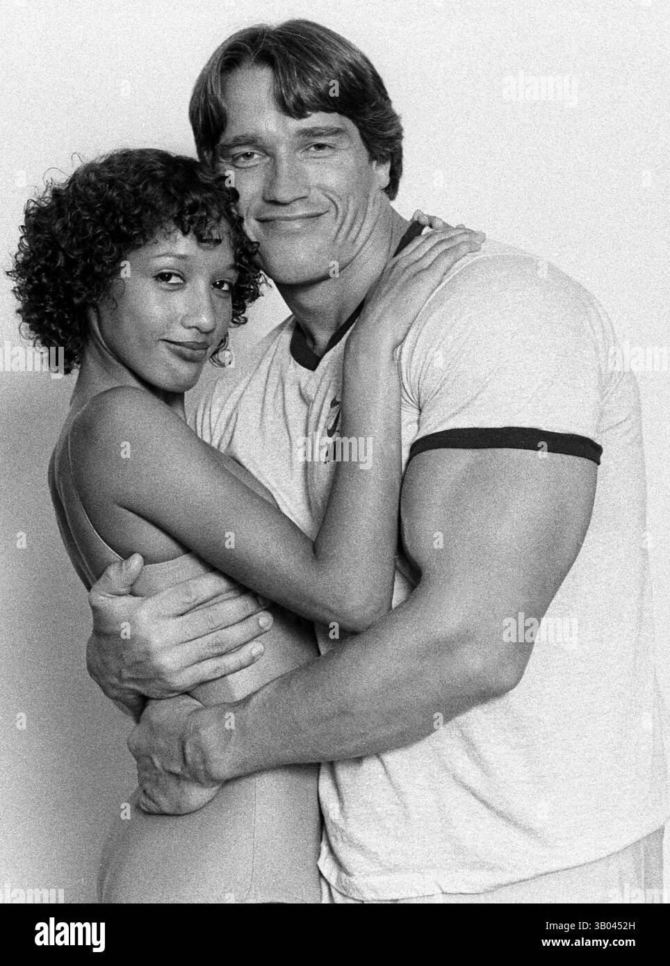 24 marzo 1979; Los Angeles, CA, Stati Uniti; il bodybuilder professionista ARNOLD SCHWARZENEGGER posa con il modello di fitness, Yvette, mentre la tiene tra le braccia durante un servizio fotografico di un libro. Nato in un piccolo villaggio in Austria, Arnold iniziò ad allenarsi con i pesi in giovane età e presto raggiunse la vetta come campione di bodybuilding. La sua pausa nella recitazione è arrivata nel film di successo del 1982 "Conan the Barbarian". Da Conan, Arnold ha mantenuto una lunga carriera come attore. Arnold divenne anche attivo nella politica degli Stati Uniti all'inizio degli anni '80 e da allora è stato eletto governatore della California per via di una controversia Foto Stock
