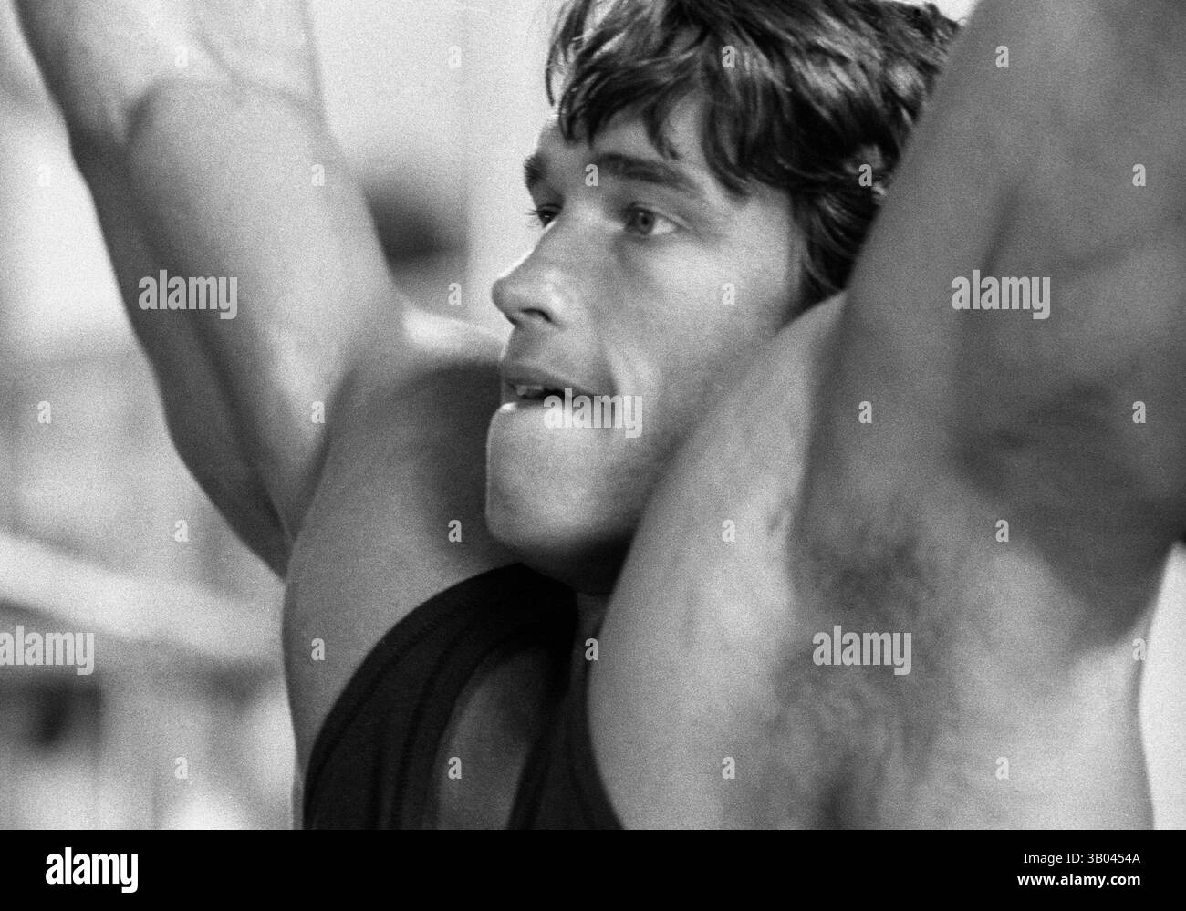 08 luglio 1979; Los Angeles, CA, Stati Uniti; il bodybuilder professionista ARNOLD SCHWARZENEGGER si aggrappa alle braccia mentre fa i tiri. Nato in un piccolo villaggio in Austria, Arnold iniziò ad allenarsi con i pesi in giovane età e presto raggiunse la vetta come campione di bodybuilding. La sua pausa nella recitazione è arrivata nel film di successo del 1982 "Conan the Barbarian". Da Conan, Arnold ha mantenuto una lunga carriera come attore. Arnold è stato attivo nella politica degli Stati Uniti a partire dai primi anni '80 e da allora è stato votato come governatore della California a causa di un controverso richiamo dell'ex governatore Gray Davis. (CR Foto Stock
