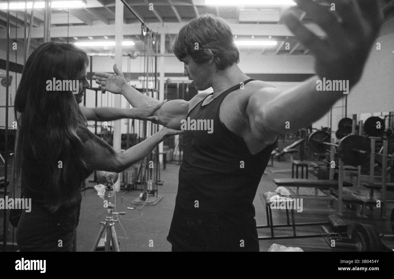 08 luglio 1979; Los Angeles, CA, Stati Uniti; il bodybuilder professionista ARNOLD SCHWARZENEGGER si allunga le braccia. Nato in un piccolo villaggio in Austria, Arnold iniziò ad allenarsi con i pesi in giovane età e presto raggiunse la vetta come campione di bodybuilding. La sua pausa nella recitazione è arrivata nel film di successo del 1982 "Conan the Barbarian". Da Conan, Arnold ha mantenuto una lunga carriera come attore. Arnold è stato attivo nella politica degli Stati Uniti a partire dai primi anni '80 e da allora è stato votato come governatore della California a causa di un controverso richiamo dell'ex governatore Gray Davis. (Immagine di credito: © Doug Foto Stock