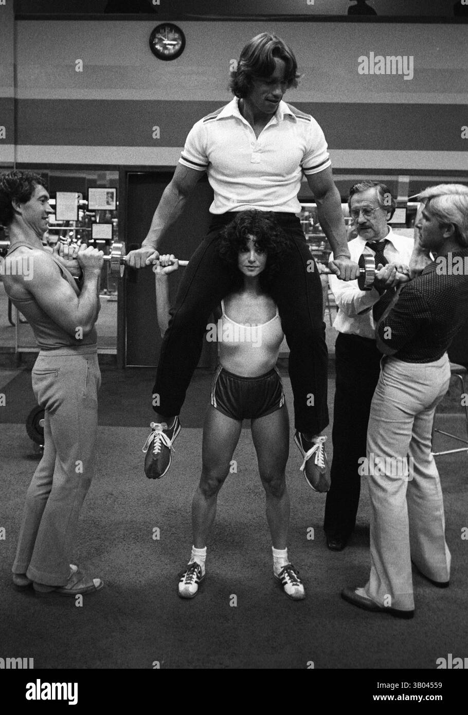 25 marzo 1979; Los Angeles, CA, Stati Uniti; il bodybuilder professionista ARNOLD SCHWARZENEGGER viene sollevato, sospeso sulle spalle della campionessa mondiale di bodybuilding femminile LISA LYON, durante un servizio fotografico. Nato in un piccolo villaggio in Austria, Arnold iniziò ad allenarsi con i pesi in giovane età e presto raggiunse la vetta come campione di bodybuilding. La sua pausa nella recitazione è arrivata nel film di successo del 1982 "Conan the Barbarian". Da Conan, Arnold ha mantenuto una lunga carriera come attore. Arnold divenne anche attivo nella politica degli Stati Uniti all'inizio degli anni '80 e da allora è stato eletto governatore del Calif Foto Stock