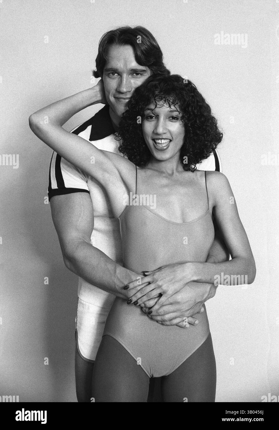 24 marzo 1979; Los Angeles, CA, USA - il bodybuilder professionista ARNOLD SCHWARZENEGGER posa con la modella di fitness, Yvette, dandole un abbraccio da dietro durante un servizio fotografico di un libro. Nato in un piccolo villaggio in Austria, Arnold iniziò ad allenarsi con i pesi in giovane età e presto raggiunse la vetta come campione di bodybuilding. La sua pausa nella recitazione è arrivata nel film di successo del 1982 "Conan the Barbarian". Da Conan, Arnold ha mantenuto una lunga carriera come attore. Arnold divenne anche attivo nella politica degli Stati Uniti all'inizio degli anni '80 e da allora è stato eletto governatore della California per via di un controverso Foto Stock