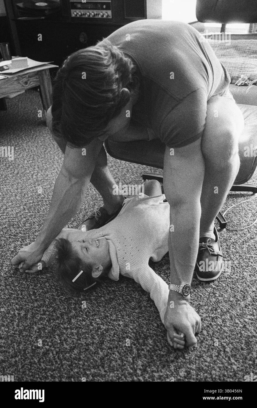 28 marzo 1979; Los Angeles, CA, Stati Uniti; il bodybuilder professionista ARNOLD SCHWARZENEGGER lotta SCHERZOSAMENTE con la figlia di un amico. Nato in un piccolo villaggio in Austria, Arnold iniziò ad allenarsi con i pesi in giovane età e presto raggiunse la vetta come campione di bodybuilding. La sua pausa nella recitazione è arrivata nel film di successo del 1982 "Conan the Barbarian". Da Conan, Arnold ha mantenuto una lunga carriera come attore. Arnold divenne anche attivo nella politica degli Stati Uniti all'inizio degli anni '80 e da allora è stato votato come governatore della California attraverso un controverso richiamo dell'ex governatore Gray Davis. ( Foto Stock