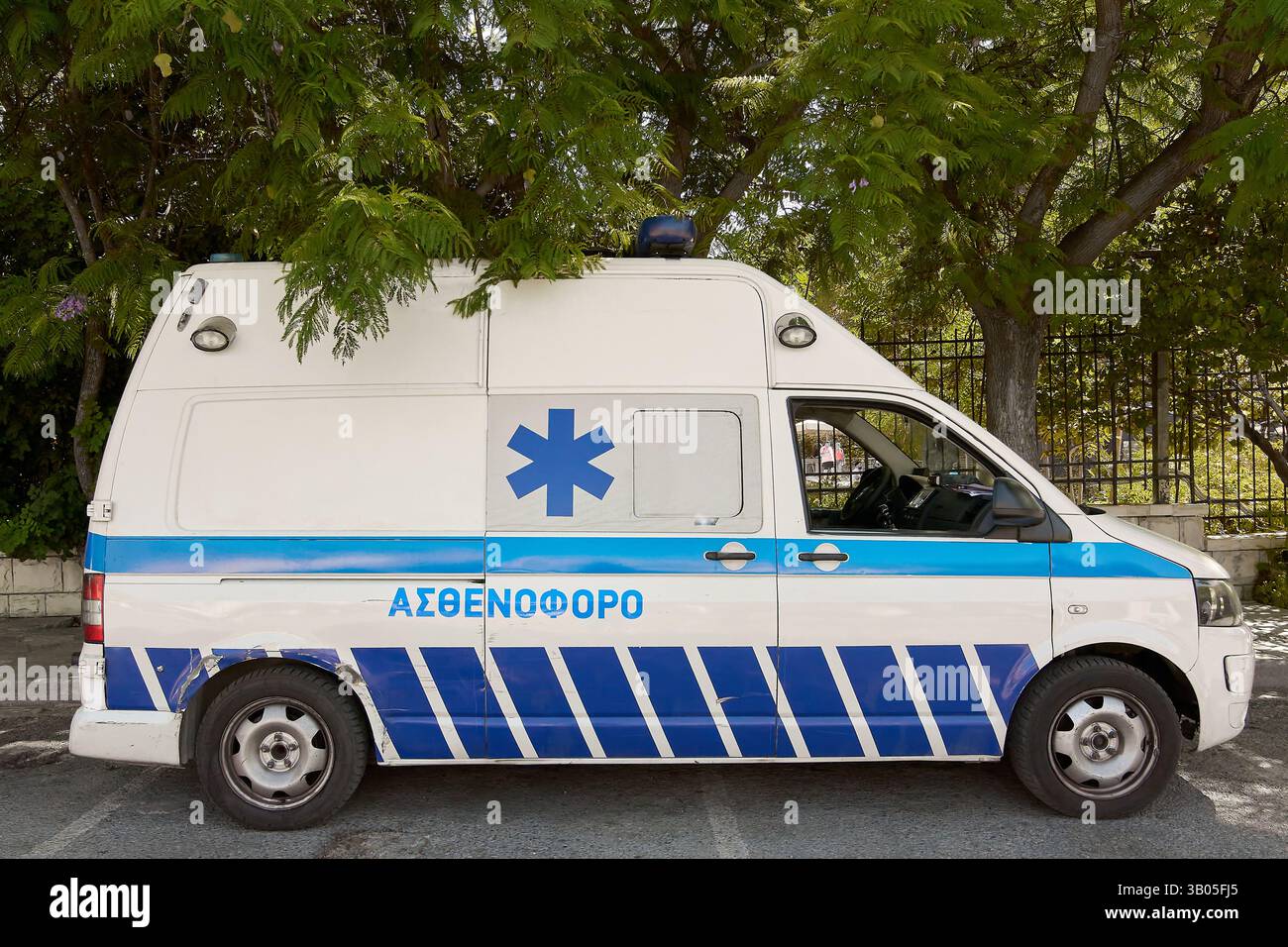 Creta. Grecia - 23 aprile 2025: Un'ambulanza bianca con contrassegni medici ufficiali è parcheggiata su una strada della città. La stella blu del simbolo vita indica eme Foto Stock