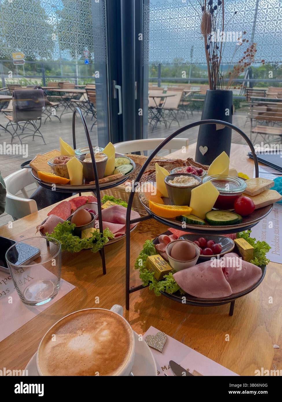 Elegante colazione europea con caffè e affettati in un accogliente ambiente da caffetteria Foto Stock